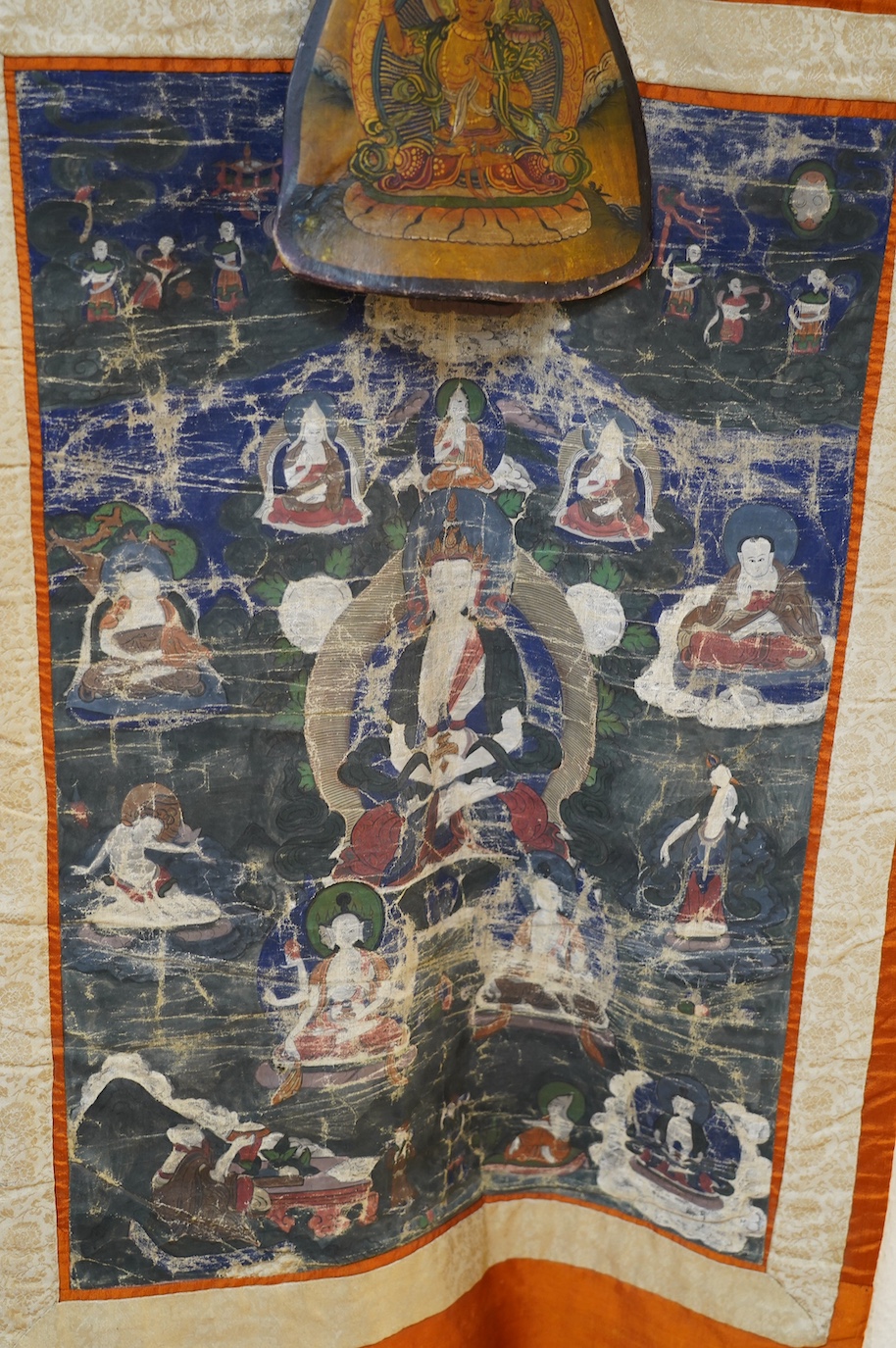 A Tibetan painted silk thangka and another painted on an ox bone, both 19th century. Condition - poor to fair
